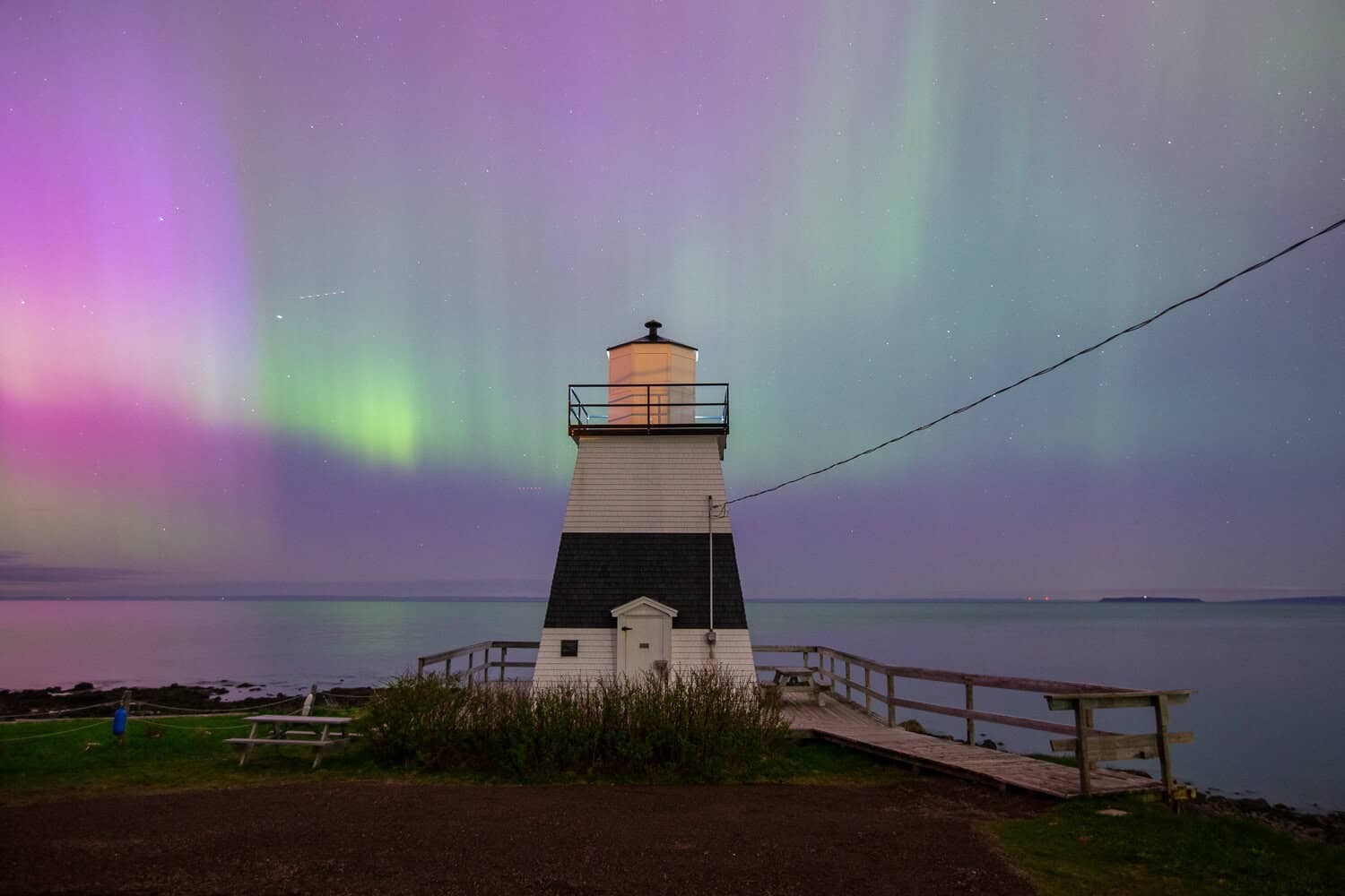 Northern Lights dance over the Margaretsville lighthouse and the Bay of Fundy.